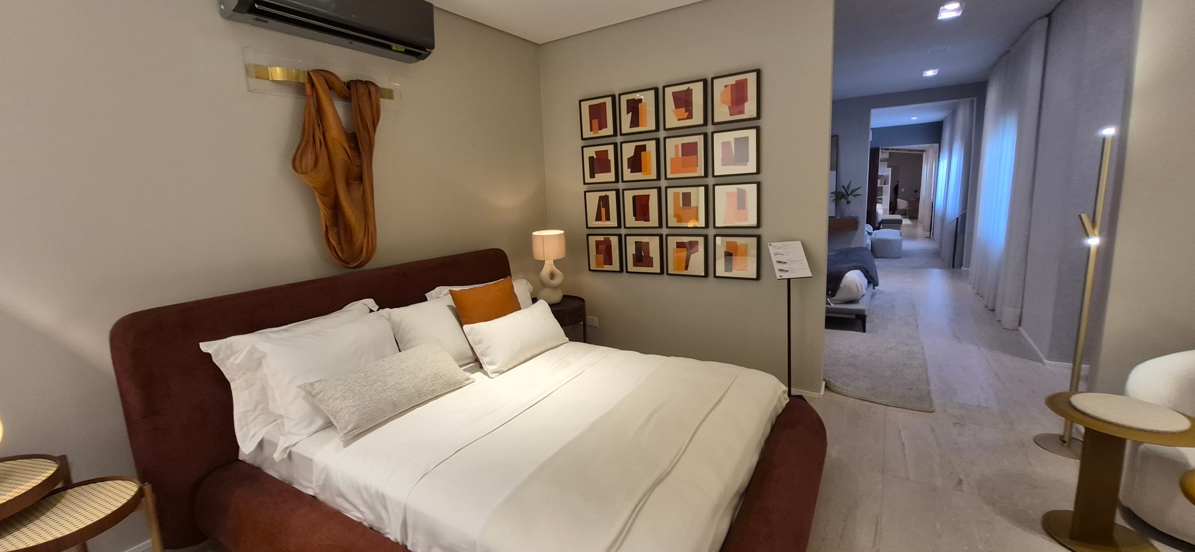 Parede de galeria com conjunto de 16 quadros no quarto